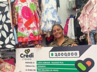 Mujer emprendedora atendiendo su tienda de ropa, recibiendo su crédito.