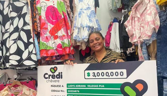 Beneficiaria de Credichevre Mujer emprendedora atendiendo su tienda de ropa, recibiendo su crédito.