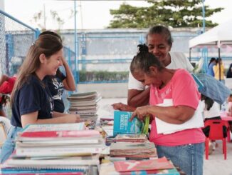 Vanessa Mercado, joven impulsora de la lectura y el evangelio en Barranquilla, organizando ferias de libros en barrios populares para fomentar el conocimiento y la fe en la comunidad.