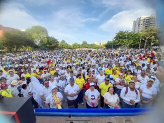 Multitud vestida de blanco con banderas de Colombia reunida en la Plaza de la Paz durante una marcha por Jesus 2024